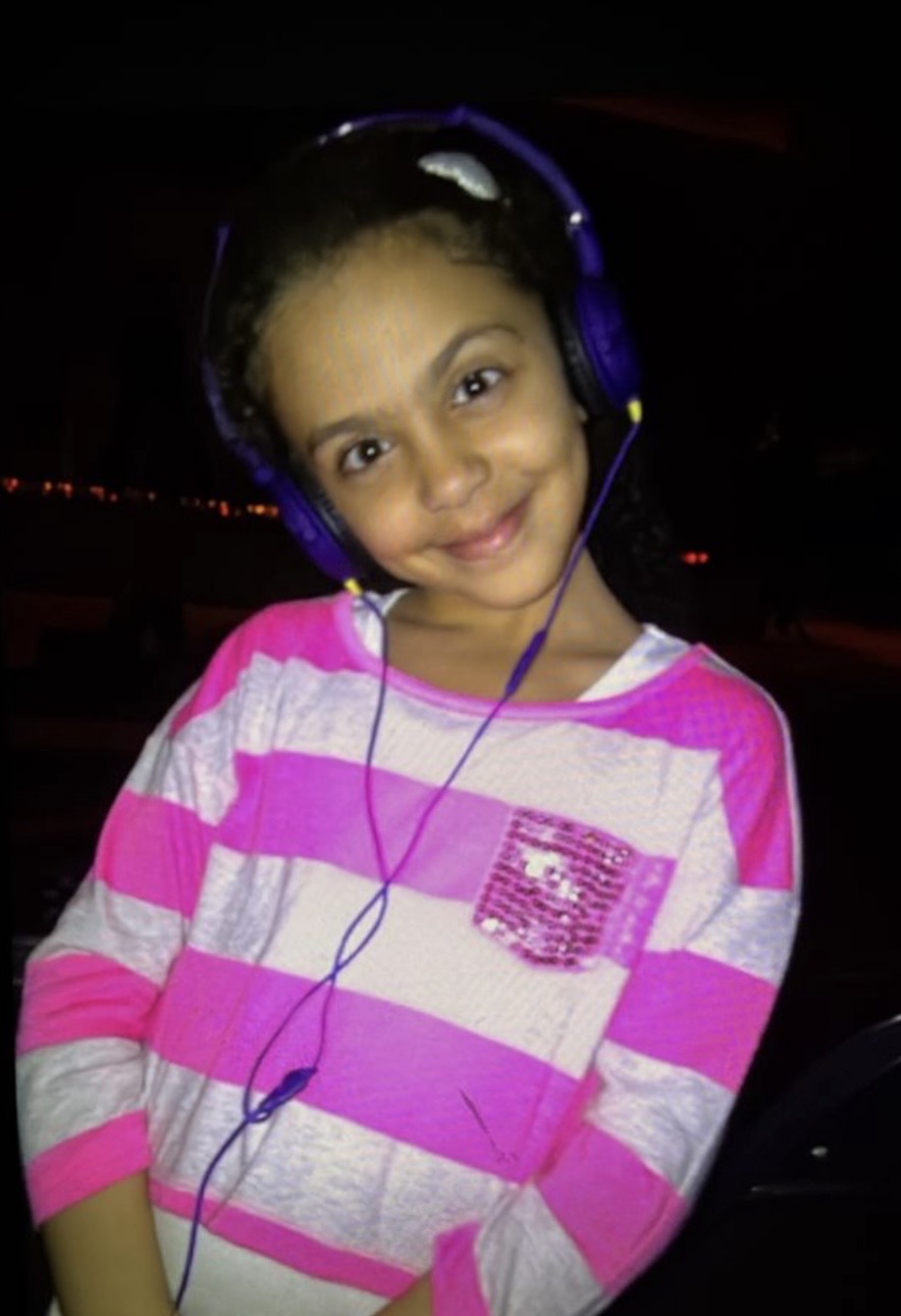 Sima as a child, headphones on, smiling